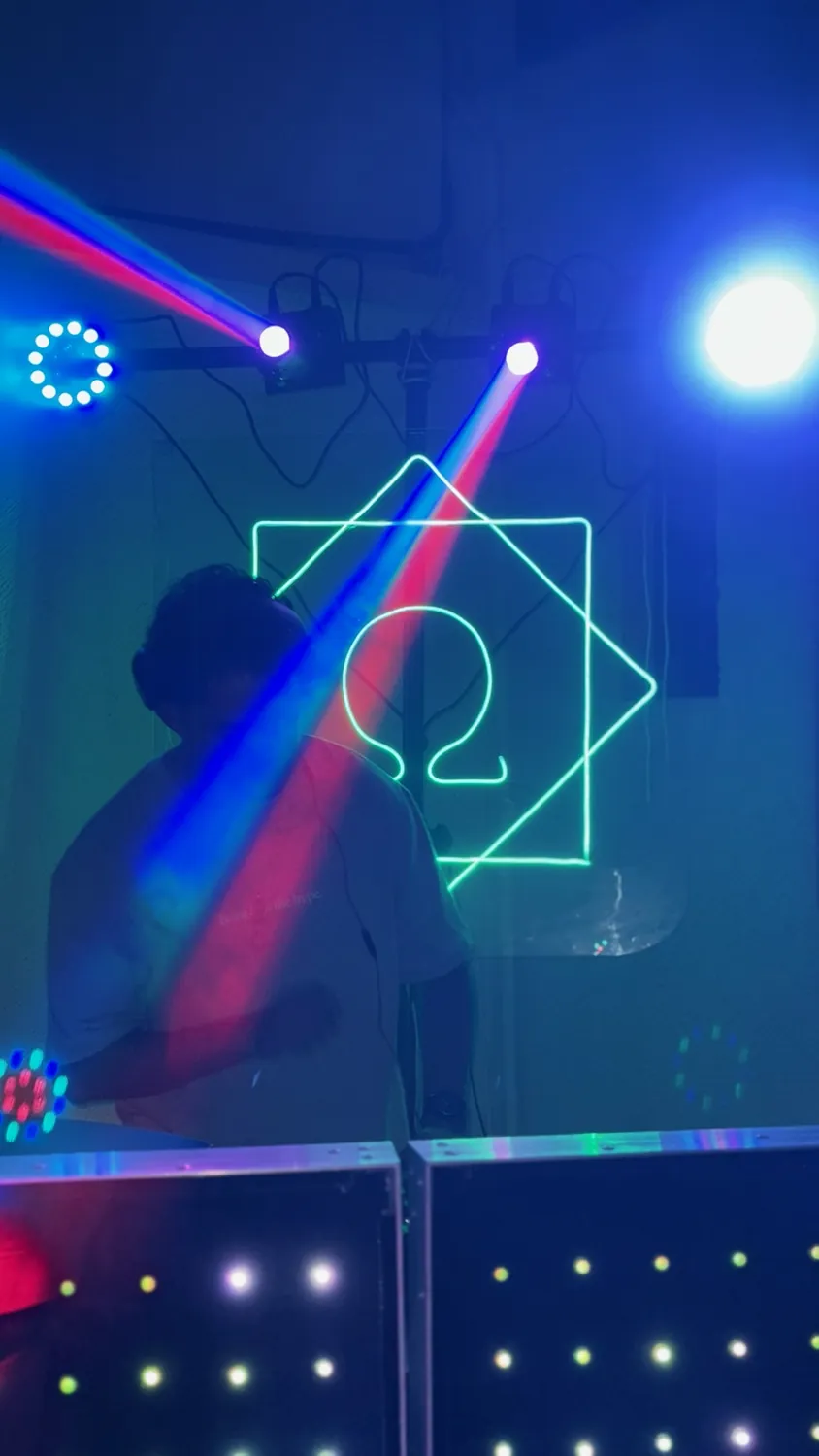 Letrero Ω en azul con haces de luz roja y azul sobre la cabina